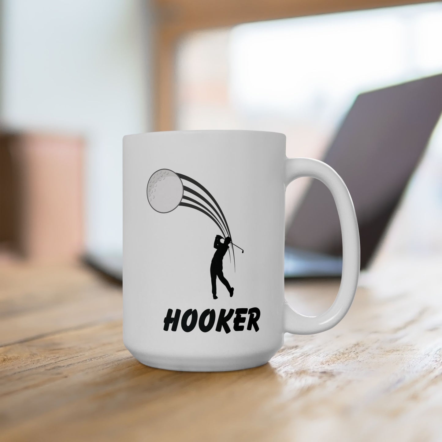 White mug with golf-themed design and 'HOOKER' text on a wooden surface.
