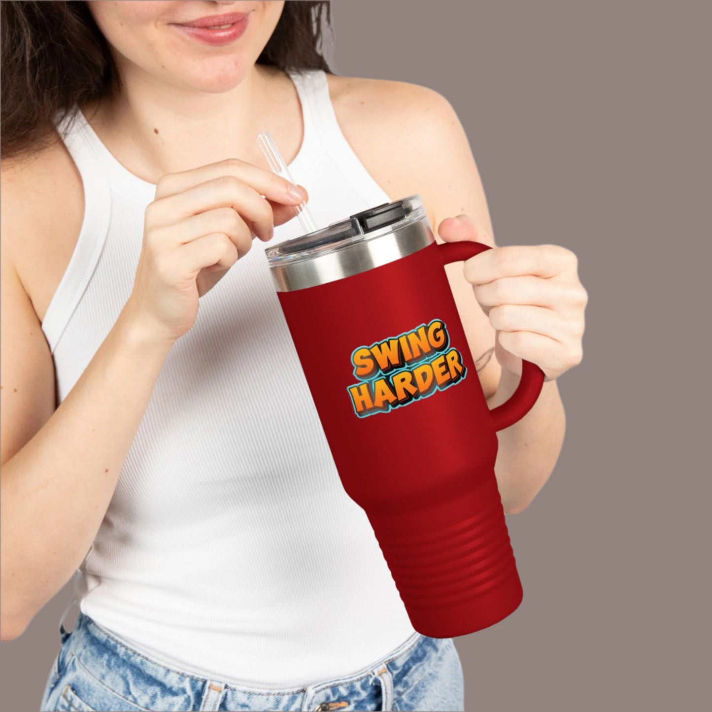 Person holding a red mug with 'SWING HARDER' text on a white background