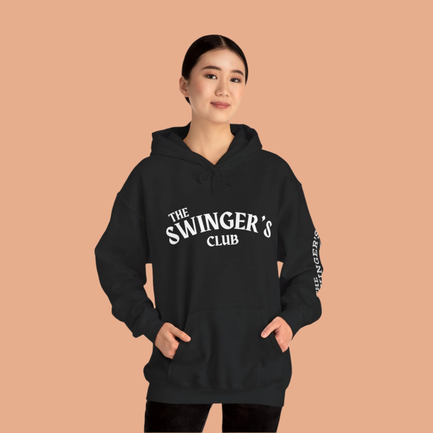 Black The Swinger's Club hoodie worn by a female model with her hands in the hoodie front pocket